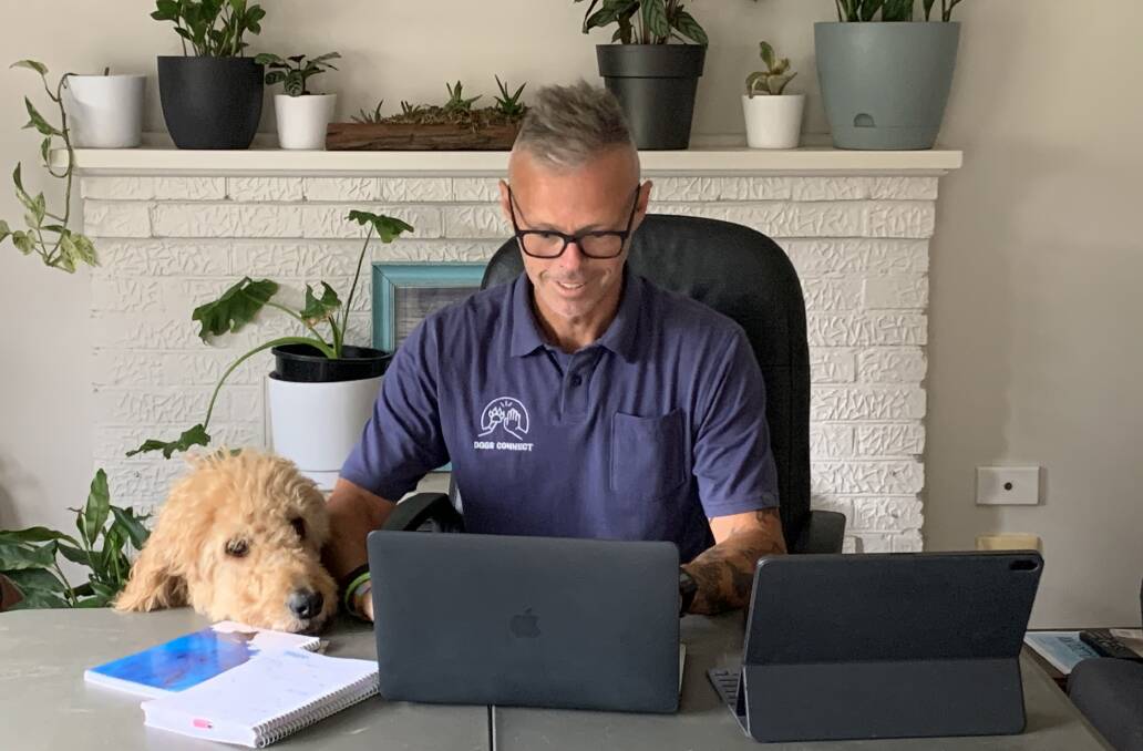 Grant Shannon and well-being dog Sonny working from home during the pandemic. Well-being dogs have proven to be valuable for students during remote learning. Picture: SUPPLIED