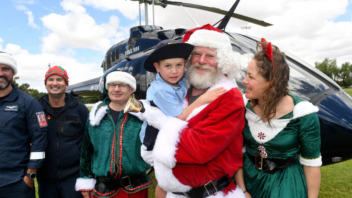 Santa Claus gives Rochester Primary School prep student Jack Bunce a hug after landing in the Power helicopter at Elmore yesterday. Picture by Noni Hyett.