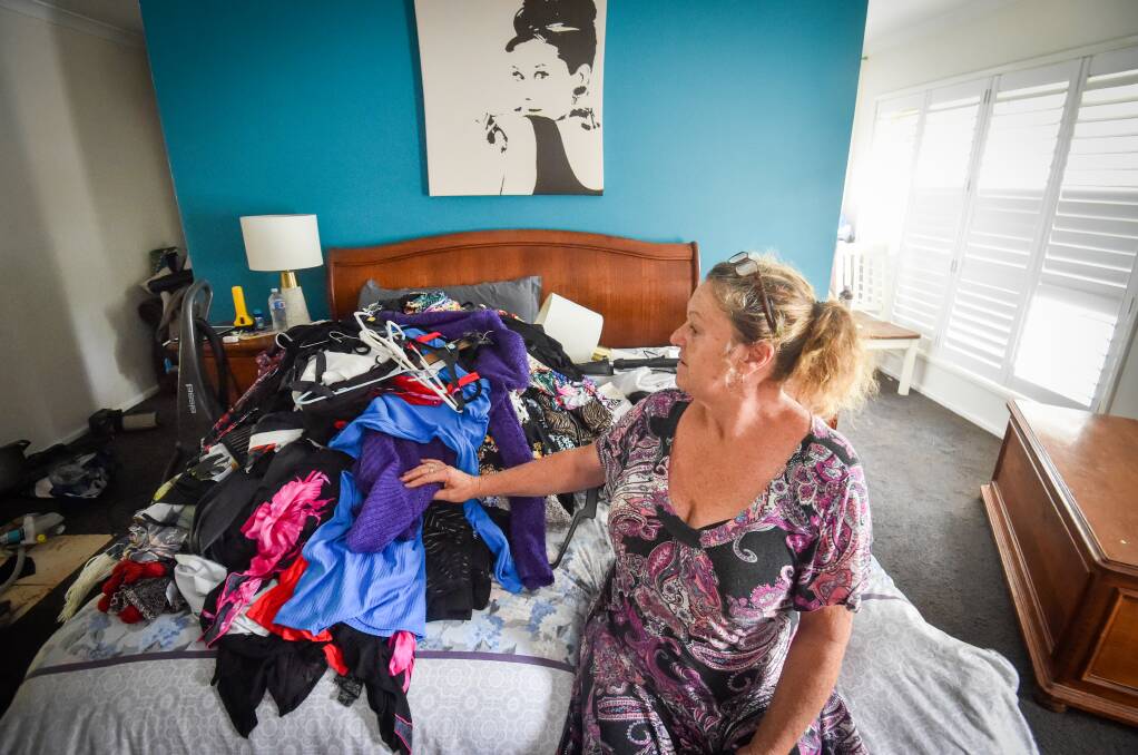 Debbie Dean with clothing in a bedroom which was flooded. Picture by Darren Howe