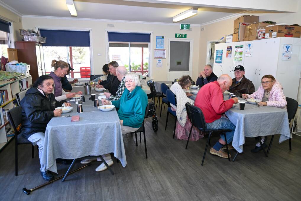 People enjoying a free meal at the Eaglehawk Community House. Picture by Enzo Tomasiello