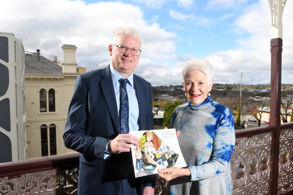 New Bendigo Health Fundraising Advisory Board chair Trevor Elliott and outgoing chair Dianne Foggo with the board's three-year strategic plan. Picture by Noni Hyett