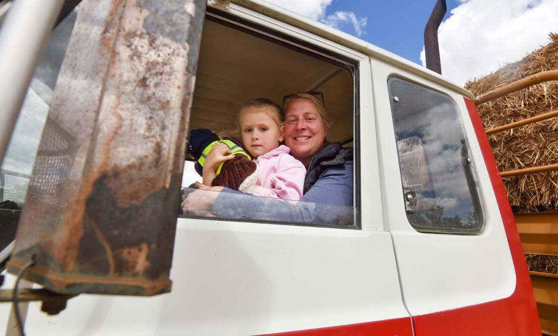 Ballendella dairy farmer April Anderson with daughter Hazel drive a truck full of hay. Picture by Darren Howe