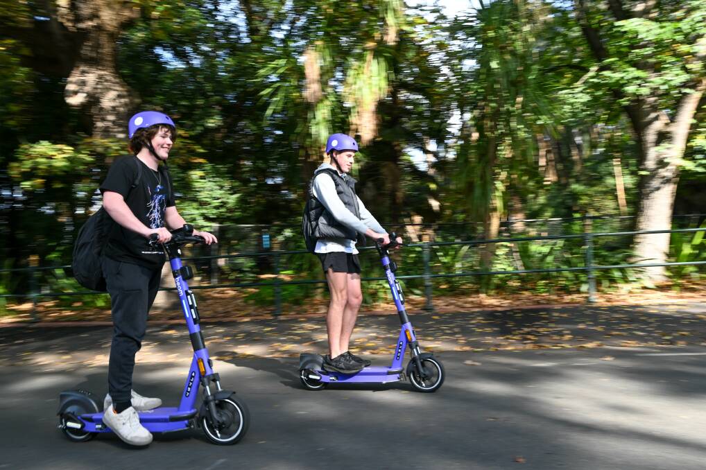 Jackson Blunt and Isiah Phillips-Adams ride Beam e-scooters past Rosalind Park. Picture by Enzo Tomasiello 