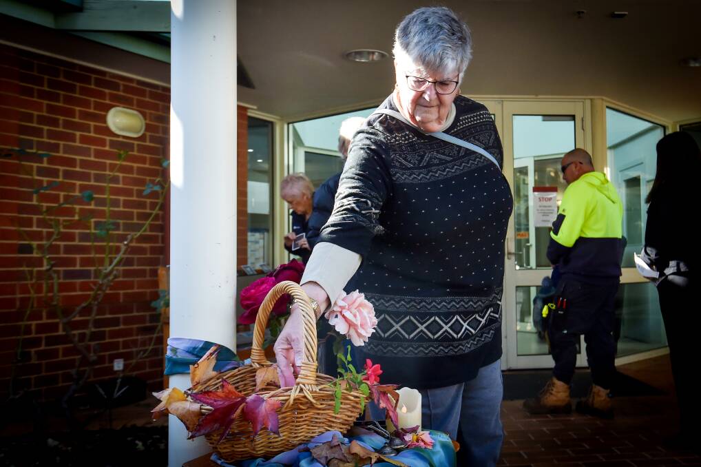 A woman places a card honouring a loved one at Bendigo Health's Scattering of Ashes ceremony. Picture by Darren Howe
