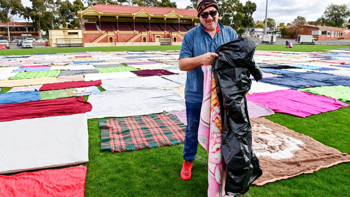 Bryan 'Cogho' Coghlan lays blankets around Queen Elizabeth Oval for the drive. Picture by Brendan McCarthy