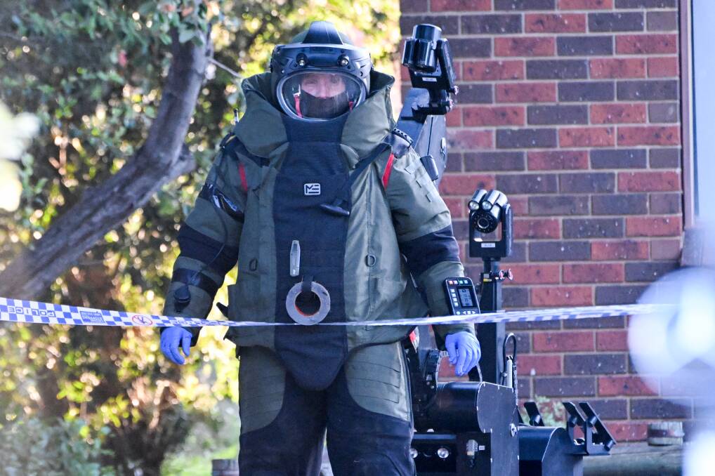 An officer in what appeared to be a blast suit at an operation on Holmes Road, Long Gully. Picture by Darren Howe