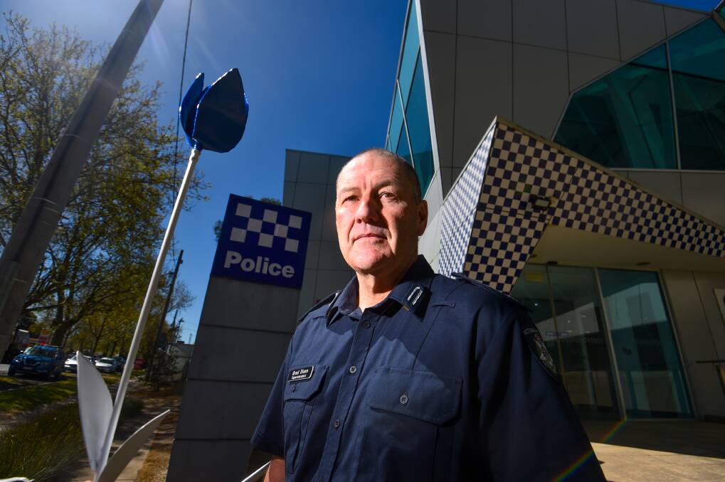 Bendigo Superintendent Brad Dixon with one of the flowers Eaglehawk Garden Sculptures has made to support Victoria Police Legacy. Picture by Darren Howe