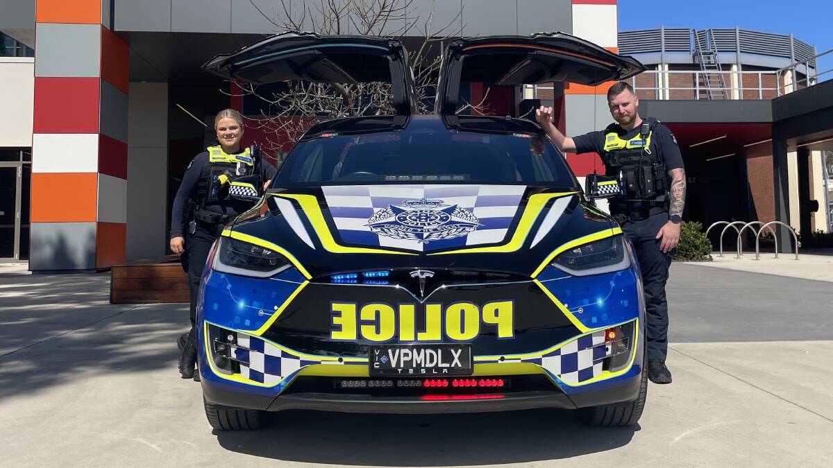 Constable Sarah Hatch and Constable Dion Jowett with a Victoria Police Tesla vehicle at La Trobe University. Picture by Jonathon Magrath