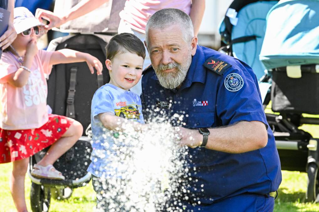 Cruz Cutting checks out a fireman's hose with some help from CFA firefighter Ross White. Picture by Darren Howe

