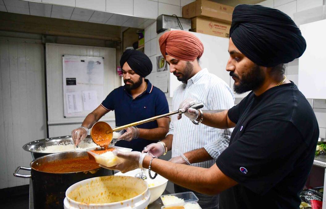 Karamjeet Singh, left in shot, helping prepare the food. Picture by Enzo Tomasiello.