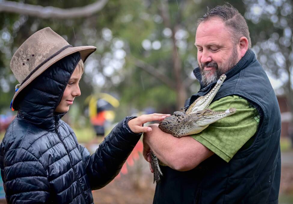 Jacob Venditti from Bendigo meets a freswater & saltwater crocodile held by Glenn James of Snake Safe Victoria. Picture by Brendan McCarthy