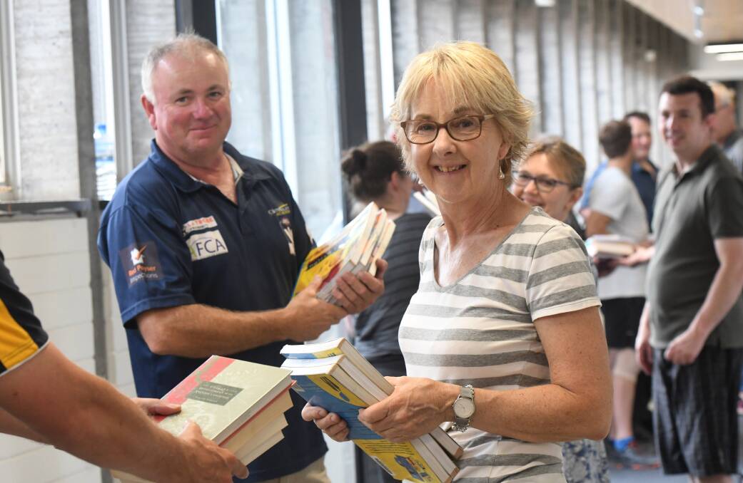 Bendigo Senior Secondary College library staff member Jenn Needham passes books along the human chain. Picture: NONI HYETT