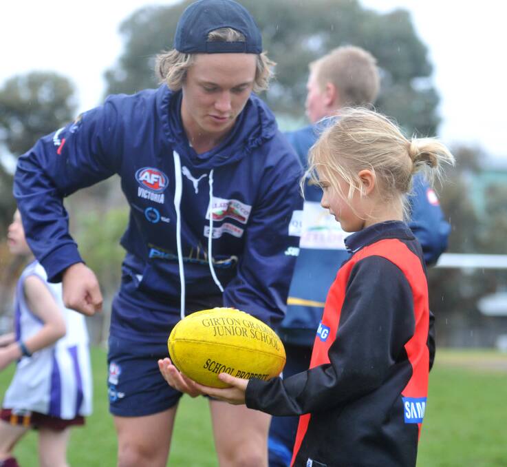 SKILLS: Bendigo Pioneer Laine Fitzgerald shows Girton Grammar junior student Ruby Flanagan the finer points of handballing during Friday afternoon's training session at Londonderry Oval. Pictures: NONI HYETT