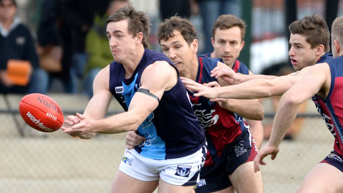 Eaglehawk's Clayton Holmes dishes off a handball. Picture: DARREN HOWE