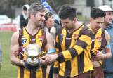 Huntly coach Hamish Morcom and Darby Walsh depart Atkins Street with the Golden City Cup after Saturday's three-point win over North Bendigo. Picture by Adam Bourke