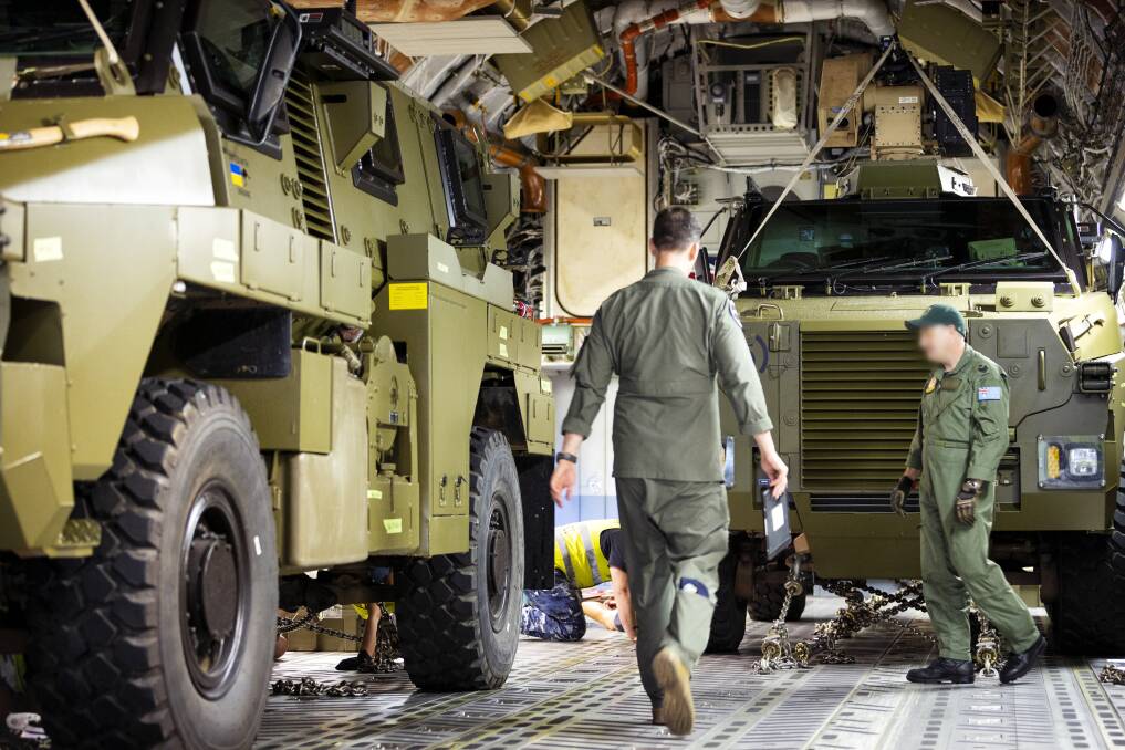 Defence workers load bushmasters onto a plane bound for Europe. Picture courtesy of Defence/Jake Badior