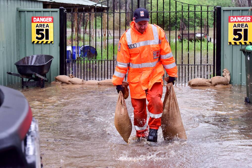 An SES volunteer moves sandbags to another part of the Goldie Street property. Picture by Brendan McCarthy.