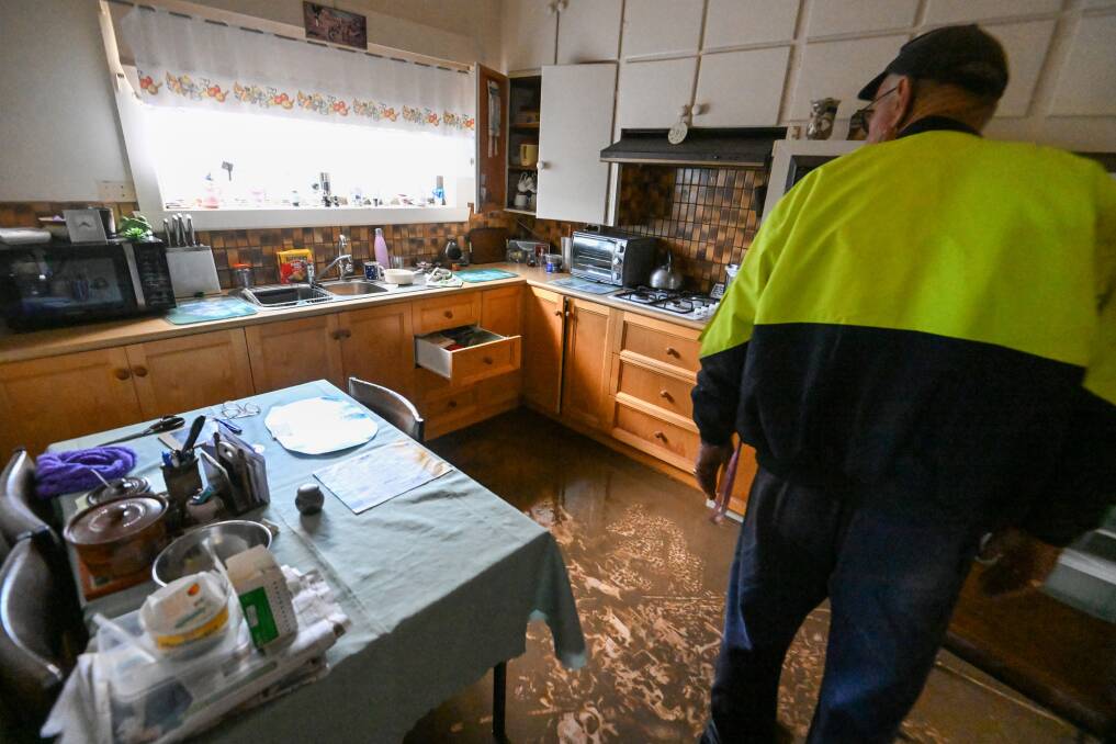 A member of the public inspecting a mud-covered kitchen as floodwater receded after Rochester's 2022 flood. Picture by Darren Howe.