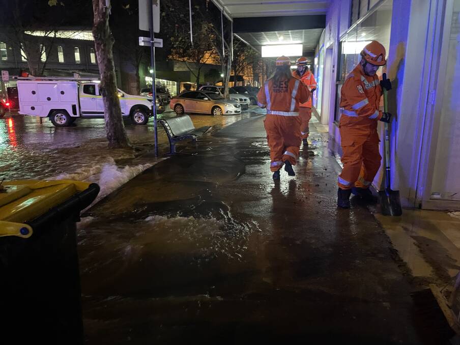 An SES crew helps clean up and keep the water out of the Endota Spa in the CBD. Picture by Juanita Greville