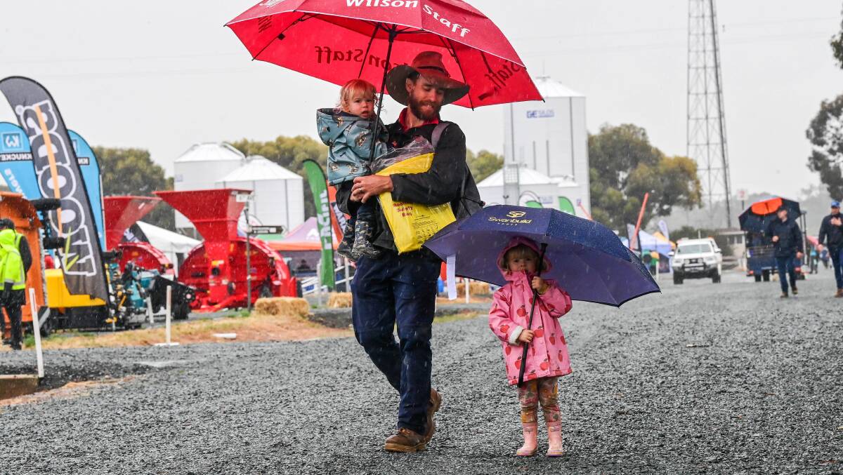 Luke Forg, of Shepparton, with Oscar, 2, and Addie, 3, came ready for the wet day at the Elmore Field Days. Picture by Brendan McCarthy