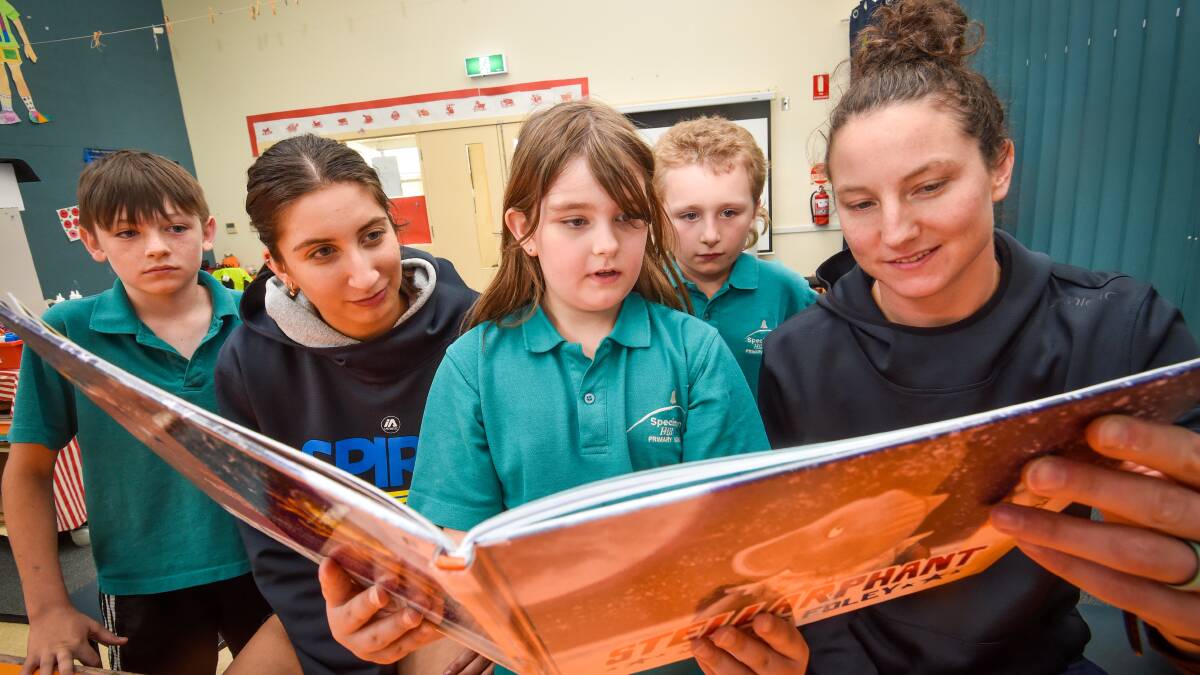 Bendigo Spirit players Sophia Locandro and Kelsey Griffin reading with Specimen Hill Primary School students Anna Bird, Brayden Webb and Ethan McDonald. Picture by Darren Howe