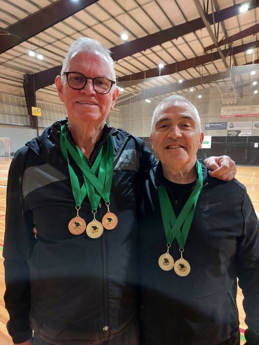 Greg Woodman (left) and Paul Henshall with their medal haul from the Pickleball Tasmanian Open, including the gold they won together in the men's 60-plus doubles.