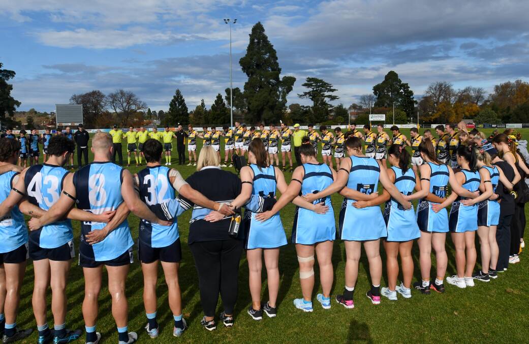 Eaglehawk and Kyneton footballers and netballers pay their respects at Canterbury Park on Saturday. Picture by Noni Hyett