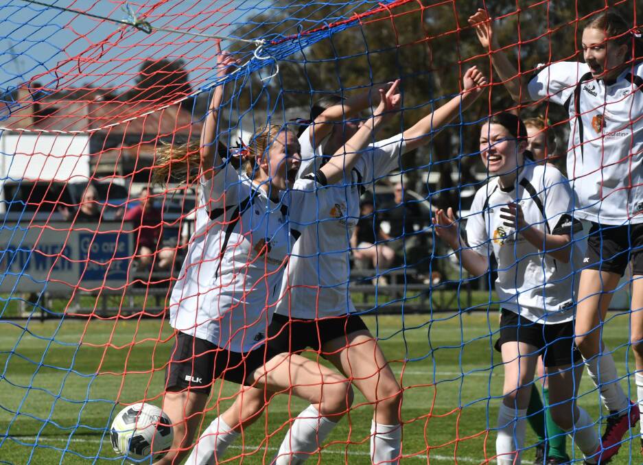 Bronte Flanagan and her Golden City team-mates celebrate their fourth goal in Saturday's under-16 girls grand final win over Castlemaine. Picture by Adam Bourke