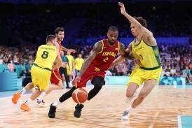 Central Victoria's Dyson Daniels and Matthew Dellavedova defend against Spain in Saturday's opening game of the Paris Olympics. Picture by Getty Images