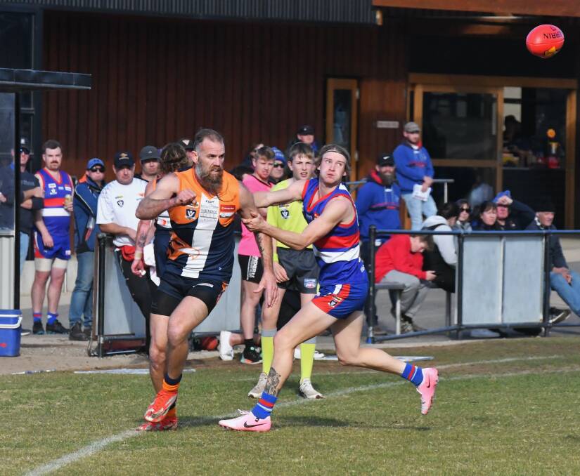 MGYCW ruckman Thomas Birch gets a handball away in front of Bailey George. Picture by Adam Bourke