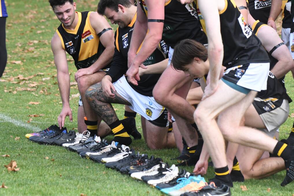 Kyneton players line their boots along the boundary line at Canterbury Park. Picture by Noni Hyett