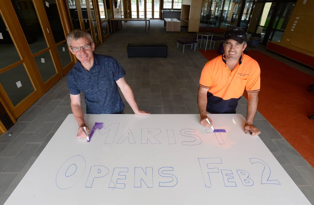 EXCITED: Principal Darren McGregor and project manager Lee Franklin putting the finishing touches ahead of opening using one of the college's many writable surfaces. Picture: JIM ALDERSEY